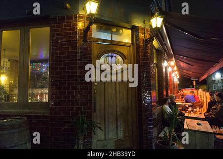 Londres, Royaume-Uni, 16 décembre 2021 : dans la vieille ville de Clapham, les pubs et les restaurants ont tout fait pour les lumières de Noël, mais les clients restent à la maison pour éviter le risque d'attraper la variante omicron du coronavirus.Tôt jeudi soir, certains pubs étaient presque complètement vides et aucun n'avait plus d'un tiers des sièges pris.Par temps doux et sec, les places en plein air restent une option pour les personnes qui souhaitent se retrouver en toute sécurité.Sans une forme quelconque de soutien gouvernemental, il semble peu probable que de nombreuses entreprises puissent rester ouvertes.Anna Watson/Alay Live News Banque D'Images