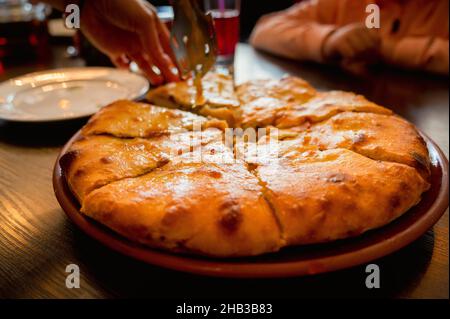 Vue rapprochée de la délicieuse tarte ossète juste cuite avec de la viande de bœuf sur l'assiette de la table Banque D'Images