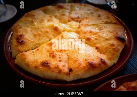 Vue rapprochée de la délicieuse tarte ossète juste cuite avec garniture de pommes de terre sur l'assiette Banque D'Images