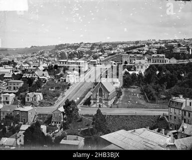 [Dunedin], studio Burton Brothers, studio de photographie, Dunedin, photographie en noir et blanc,Vue sur le logement dans un quartier résidentiel, petite église en pierre en vue au centre de l'image Banque D'Images