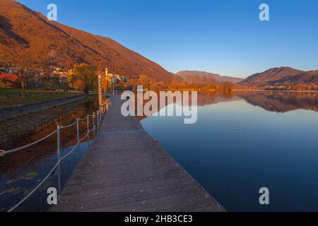 Petit village surplombant le lac pendant un coucher de soleil d'automne vu depuis la jetée en bois Banque D'Images