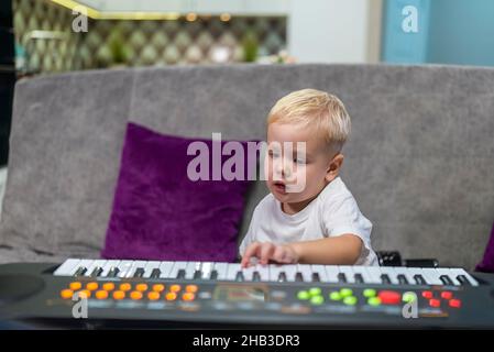 petit garçon apprenant à jouer du piano à la maison Banque D'Images