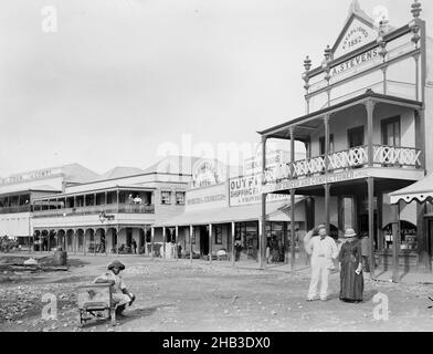 [Suva Street.], studio Burton Brothers, studio de photographie, 1884, Dunedin,Photographie en noir et blanc, scène de rue avec large route.Homme (avec chapeau) assis sur le chariot.Homme et femme (avec chapeaux) au centre à droite.Derrière se trouve A. Stevens magasin (deux étages avec balcon), et quatre autres magasins tous avec des vérandas, à l'extrême gauche deux avec balcons Banque D'Images