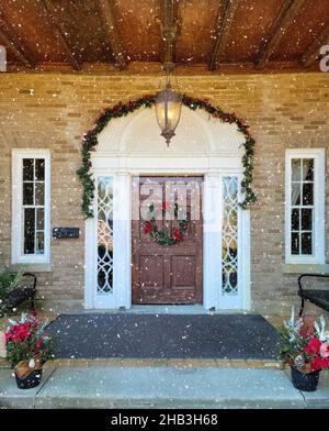 Porte avant en bois avec couronne de Noël et guirlande de décorations en flocons de neige Banque D'Images