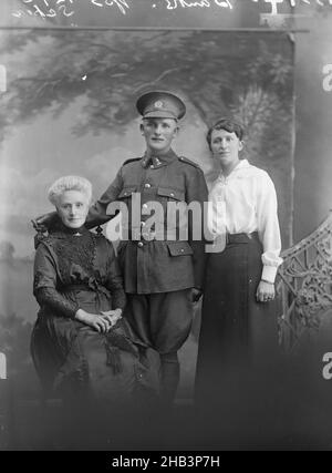 Portrait d'un soldat non identifié et de deux femmes non identifiées [banques inscrites], Berry & Co, studio de photographie, 1916-1917, Wellington,Portrait d'un soldat néo-zélandais dans l'uniforme d'un fusil de la Brigade du fusil, debout entre deux femmes, une assise et une debout.La femme plus âgée peut être sa mère, la plus jeune peut être une sœur.Des cinq soldats néo-zélandais avec le nom de famille 'Bankss' qui ont servi dans la Brigade des fusils à fusil en WW1 Banque D'Images