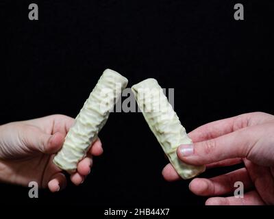 Ukraine.05th décembre 2021.Dans cette illustration, les mains ont vu tenir des biscuits d'en-cas blancs Twix sur un fond noir.(Photo de Valera Golovniov/SOPA Images/Sipa USA) crédit: SIPA USA/Alay Live News Banque D'Images