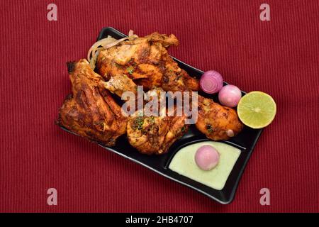 Poulet grillé de style indien avec chutney, oignon et citron dans une assiette Banque D'Images
