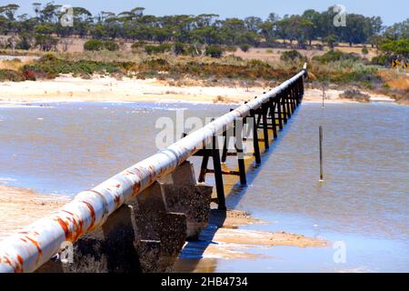 Pipe d'eau de fond sur des peuplements traversant le lac salé, Wongan Hills, Australie occidentale Banque D'Images