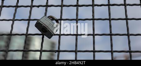 Cadenas accrochés à un câble métallique.Écluses d'amour sur la clôture de filet à la brigade de New Wesminster en Colombie-Britannique.Vue sur la rue, personne, mise au point sélective, rétrogro flou Banque D'Images