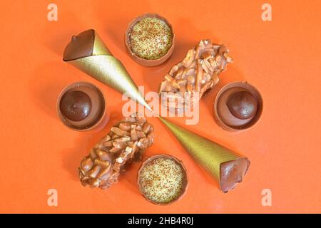 Vue de dessus de plusieurs pralines au chocolat sur fond pastel.Vue de dessus des pralines au chocolat.Pose à plat.Chocolat noir et chocolat au lait de luxe Banque D'Images