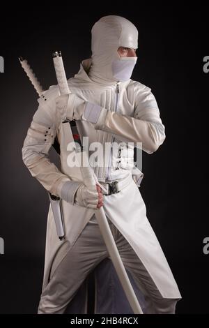 homme en vêtements ninja blancs dans le studio sur fond noir Banque D'Images