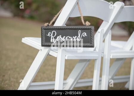 Affiche de siège sur chaise blanche lors de la cérémonie de mariage en plein air Banque D'Images