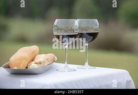 Cérémonie de mariage de pain de rupture rempli de verres à vin et de pain à l'extérieur Banque D'Images