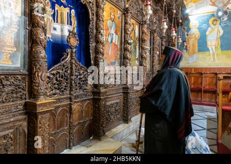 Un chrétien orthodoxe éthiopien prie devant l'iconostase à l'intérieur de l'église orthodoxe grecque orientale de l'Annonciation, également connue sous le nom d'église Saint-Gabriel ou l'église orthodoxe grecque de Saint-Gabriel dans la ville de Nazareth, dans le nord d'Israël Banque D'Images