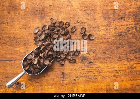 Petit-déjeuner au chocolat sucré, flocons de céréales dans une cuillère sur une table en bois.Vue de dessus. Banque D'Images