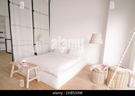 chambre rose pâle dans un style minimaliste avec un lit double avec des espaces pour les vêtements et pour dormir.Photo de haute qualité Banque D'Images