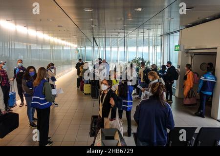 Aéroport international de Schiphol, Amsterdam, pays-Bas.9th décembre 2021.Le personnel dirige les passagers arrivant d'Afrique du Sud par le biais de tests PCR. Banque D'Images