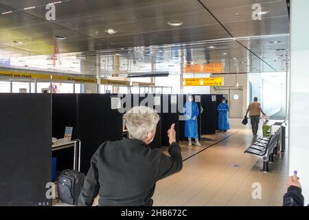 Aéroport international de Schiphol, Amsterdam, pays-Bas.9th décembre 2021.Le personnel dirige les passagers arrivant d'Afrique du Sud par le biais de tests PCR. Banque D'Images