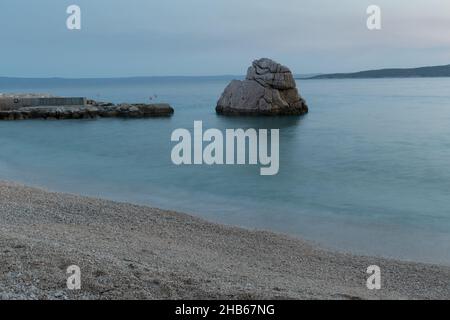 Magnifique paysage marin, roche dans la mer Adriatique près de Baska Voda en Croatie à la tombée de la nuit d'été.Plage d'Ikovac Banque D'Images