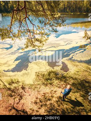 Vue de haut en bas femme senior stand tenant des bâtons nordiques et profiter de la vue panoramique sur le lac en belle journée ensoleillée.Texture et nature bien-être concept Banque D'Images