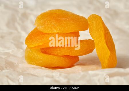 Photo d'abricots séchés sur fond de papier froissé, d'abricots séchés reposant sur des abricots séchés Banque D'Images