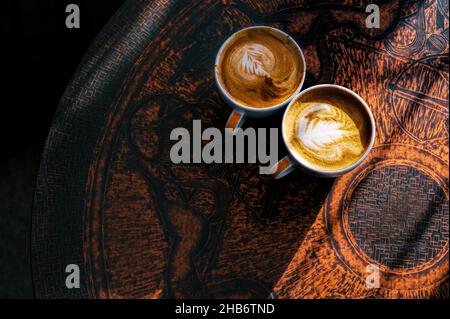 Deux tasses de café sur une table vintage brune avec de beaux latte. Vue de dessus Banque D'Images