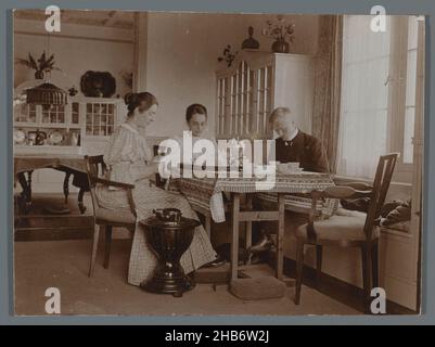 Compagnie buvant le thé à la table, avec Cornelia Hendrika Jonker à gauche, Cornelia Hendrika Jonker (cercle de), pays-Bas (éventuellement), 1895 - 1910, support photographique, hauteur 83 mm × largeur 112 mm Banque D'Images