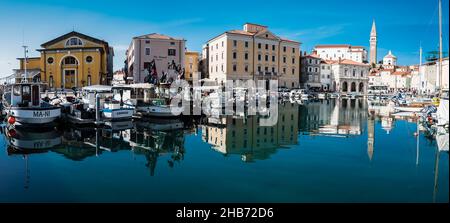 Piran, Slovénie - 04 07 2018: Le port de Piran avec des bateaux et des maisons réfléchissants Banque D'Images