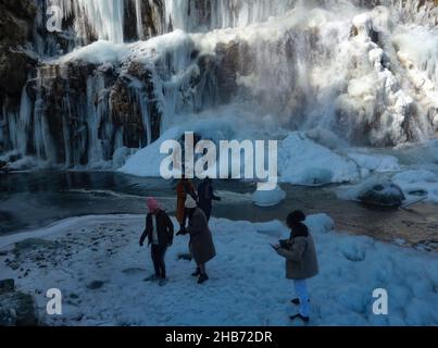 Srinagar, Inde.17th décembre 2021.Visiteurs vus à côté d'une chute d'eau gelée le 17 décembre 2021 à Drung, à l'ouest de Srinagar, la capitale estivale du Cachemire indien.Le mercure dans le Cachemire a chuté à moins 12,3 °C, ce qui en fait la première nuit de décembre la plus basse.l'homme météorologique a prévu principalement le temps sec sur Jammu-et-Cachemire et Ladakh pour les prochains jours, après 'Chillai-Kalan', la période de 40 jours de l'hiver le plus dur au Cachemire, qui commence le 21 décembre.(Photo de Sajad Hameed/Pacific Press) crédit: Pacific Press Media production Corp./Alay Live News Banque D'Images