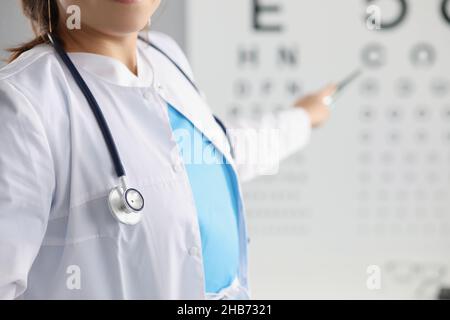 La femme est médecin de l'œil sur la lettre sur le tableau des tests oculaires Banque D'Images