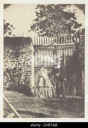 Portrait d'un homme et d'une femme inconnus avec parasol, debout devant une clôture, Paul Marès (attribué à), France, 1850 - 1855, papier, imprimé salé,hauteur 214 mm × largeur 147 mm Banque D'Images