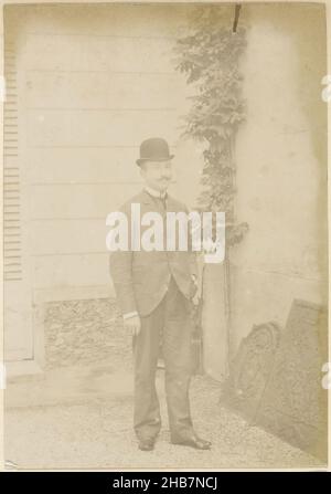 Portrait d'un homme français portant un chapeau de melon et une cigarette, debout, partie d'un album photo d'un photographe amateur français avec des photos d'une famille, distillerie Delizy & amp; Doistau fils, l'armée et les lieux d'intérêt en France., anonyme, France, c.1900 - c.1910, papier, imprimé albumine, hauteur 164 mm × largeur 115 mm Banque D'Images