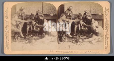 Représentation de six hommes mangeant et buvant dans une maison épave en Afrique du Sud, Remington Scouts prenant le déjeuner dans une maison de Boer - naufragé par Kaffirs, Yaasfontein, Afrique du Sud (titre sur objet), anonyme, éditeur: Underwood et Underwood (mentionné sur objet), Zuid-Afrika, éditeur:New York (ville) (éventuellement), 1900, carton, papier, imprimé albumine,hauteur 88 mm × largeur 178 mm Banque D'Images