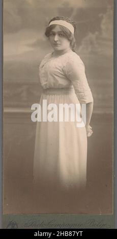 Portrait d'une femme debout inconnue dans une robe, photo Compagnie Belge (mentionnée sur l'objet), Bruxelles, c.1870 - c.1910, support photographique, carton, hauteur 153 mm × largeur 76 mm Banque D'Images