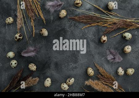 Cadre avec œufs de Pâques et plumes sur fond sombre.Flat Lay, vue de dessus.Concept de vacances de Pâques. Banque D'Images