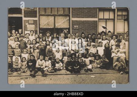 Portrait de groupe d'enfants et de femmes inconnues devant une épicerie (vraisemblablement) à Westzaan, anonyme, Westzaan, dans ou après 1907 - c.1915, support photographique, impression en gélatine argentée, hauteur 88 mm × largeur 137 mm Banque D'Images