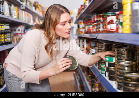 Femelle dans le magasin contenant du poisson conservé Banque D'Images