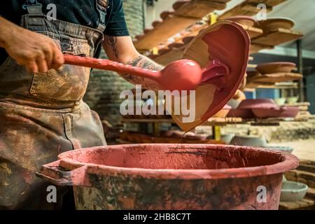 Poterie PAS à Mas-Saintes-Puelles, France. Après que les moules sont tournés de l'argile et le même jour, le premier glaçure est appliqué à la poterie. Banque D'Images