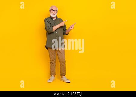 Portrait de pleine longueur de la personne positive gaie indique les doigts vide espace isolé sur fond jaune Banque D'Images