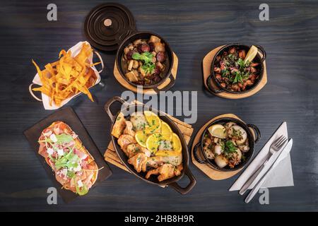 Des plats traditionnels portugais de viande et de poisson sont servis sur une table en bois Banque D'Images