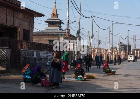 Srinagar, Inde.17th décembre 2021.Les femmes Fisher attendent des clients devant une Jamia Masjid fermée à Srinagar.les autorités indiennes considèrent la mosquée comme un lieu de rencontre, un centre névralgique pour les manifestations et les affrontements qui défient la souveraineté de l'Inde sur la région du Cachemire.Pour les musulmans cachemiriens, c'est un lieu sacré pour les prières du vendredi et un endroit où ils peuvent élever leur voix pour les droits politiques.Dans cette dispute amère, la mosquée de la ville principale du Cachemire est restée fermée pour 19 vendredi consécutifs.Crédit : SOPA Images Limited/Alamy Live News Banque D'Images