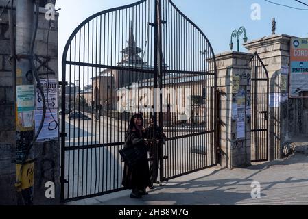 Srinagar, Inde.17th décembre 2021.Une femme se tient devant un Jamia Masjid fermé à Srinagar.les autorités indiennes considèrent la mosquée comme un lieu de trouble, un centre névralgique pour les manifestations et les affrontements qui défient la souveraineté de l'Inde sur la région du Cachemire.Pour les musulmans cachemiriens, c'est un lieu sacré pour les prières du vendredi et un endroit où ils peuvent élever leur voix pour les droits politiques.Dans cette dispute amère, la mosquée de la ville principale du Cachemire est restée fermée pour 19 vendredi consécutifs.Crédit : SOPA Images Limited/Alamy Live News Banque D'Images