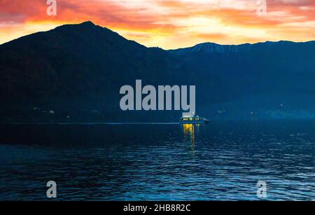 Vue fantastique sur les voiles illuminées de l'heure bleue sur le lac de Côme d'un océan à l'autre en direction de la ville de Côme.Coucher de soleil rose sur l'Alp. Italienne Banque D'Images