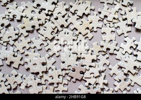 Beaucoup de pièces de puzzle en carton texturé gris clair sur une table, activité de week-end à l'intérieur pour jouer avec les enfants à la maison Banque D'Images