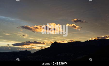 de beaux nuages orange dorés au coucher du soleil sur la côte méditerranéenne et silhouettes de collines Banque D'Images