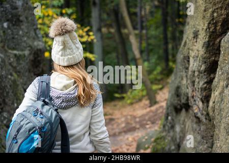 Femme randonneur vêtue d'un pull et d'un chapeau tricotés dans la forêt d'automne.Randonnée en montagne.Touriste féminin dans des vêtements chauds Banque D'Images