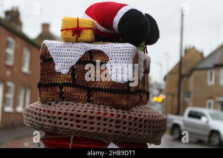 Un chapeau pour une boîte postale en Ely tricoté par le bombardier Secret Yarn, avec le Père Noël montant une cheminée Banque D'Images
