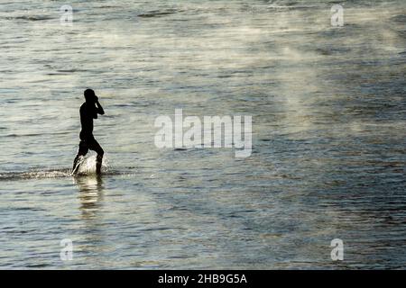 Homme sortant lentement de la mer de la plage d'Ondina après avoir été baigné.Salvador Bahia Brésil. Banque D'Images