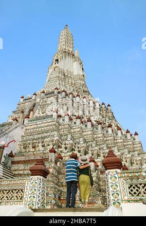 Couple grimpant jusqu'à Phraprrang, l'épi central de Wat Arun ou le Temple de l'Aube, l'un des monuments emblématiques de Bangkok, en Thaïlande Banque D'Images