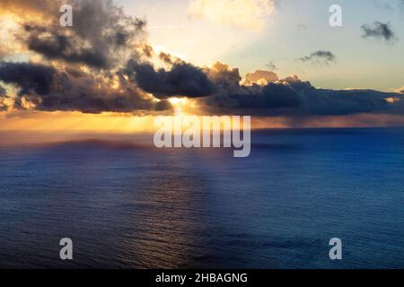 Coucher de soleil à la mer avec nuages orageux dans le ciel, approprié comme image d'arrière-plan Banque D'Images